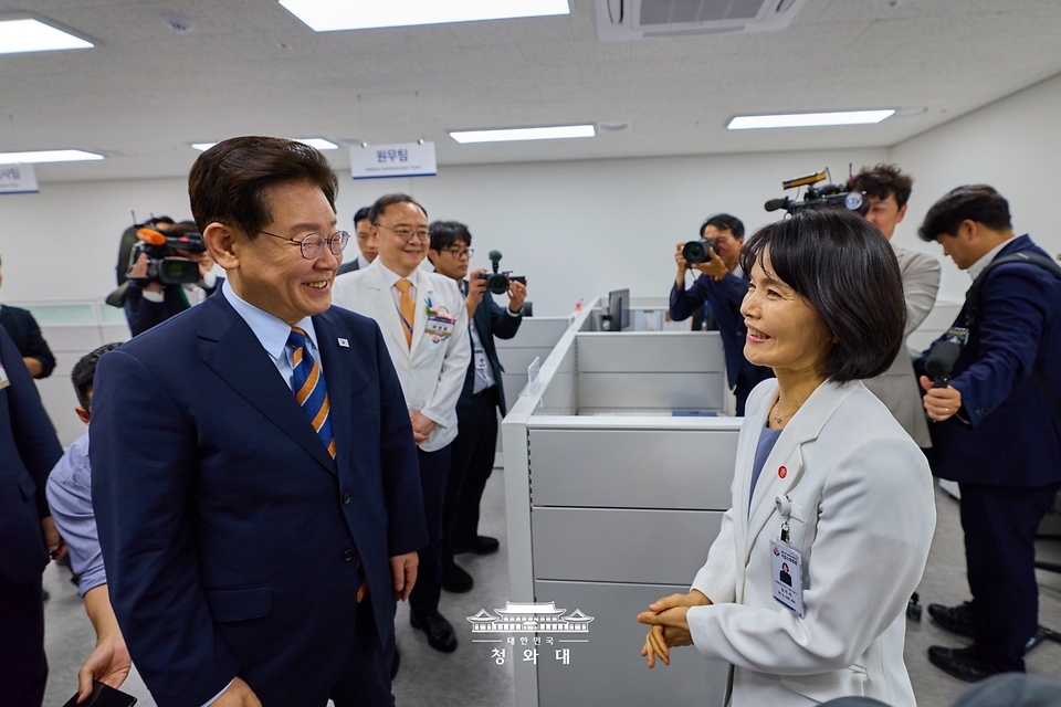 이재명 대통령이 8월 11일 충북 음성 국립소방병원 원무과 사무실에서 심미선 간호행정교육과장과 대화하고 있다.