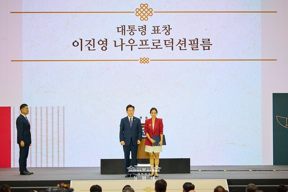 이재명 대통령이 9월 28일 인천 송도에서 열린 제20회 세계한인의 날 기념식에서 이진영 나우프로덕션필름 대표에게 대통령 표창을 수여한 후 기념촬영을 하고 있다.