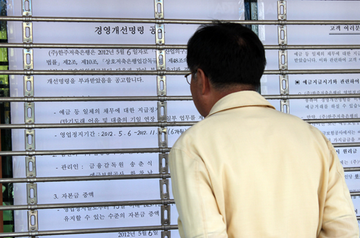 금융위원회가 6일부터 영업정지를 포함한 경영개선명령을 내린 충남 연기군 조치원읍에 있는 한주저축은행 앞에서 예금주가 걱정스럽게 금융위원회의 공고문을 살피고 있다. (사진=저작권자 (c) 연합뉴스. 무단전재-재배포금지)