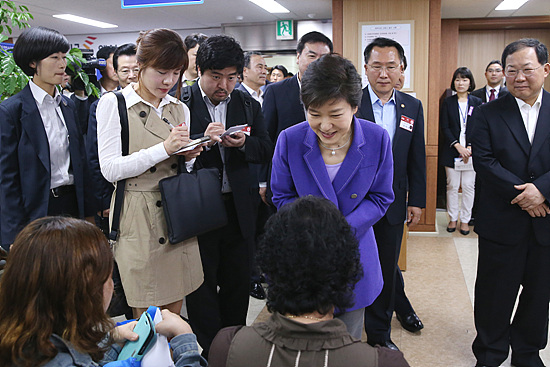 박근혜 대통령이 국민행복기금 접수 창구에서 채무조정 접수를 기다리는 국민들을 격려하고 있다. (사진=청와대)