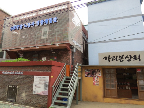 구로공단의 옛 모습과 여공들의 생활공간이었던 쪽방을 재현한 노동자생활체험관 전경, 우측에 여공들의 생필품 구입과 주전부리 터 가리봉상회도 함께 조성했다. 