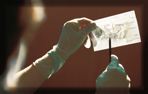 범죄현장에 남아있는 지문에 대해 분말 등을 활용해 감정할 수 있는 상태로 현출하는 장면 <사진=경찰청 />