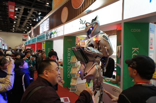 박람회장에서 K팝에 맞춰 춤추는 로봇을 보며 즐거워하는 베이징 시민들.