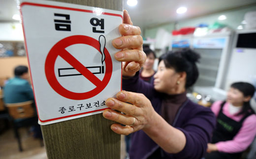 서울 종로구 한 음식점에서 직원이 음식점 내 금연을 알리는 안내문을 부착하고 있다.(사진=저작권자(c)연합뉴스.무단전재-재배포금지)