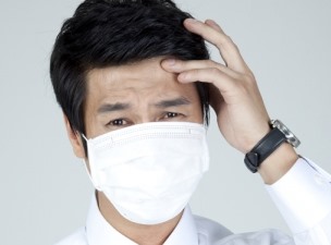 마스크를 쓰고 머리를 짚고있는 남자