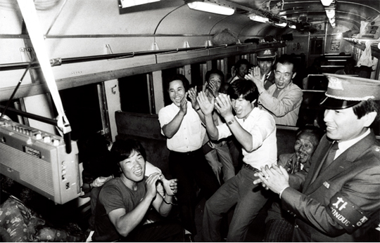 1986년 6월 3일 오전 3시께 광주발 용산행새벽 열차에서 승객이 갖고 탄 휴대용 라디오로 한국과 아르헨티나의 월드컵 축구경기 중계방송을 들으며 승객과 승무원들이 응원에열을 올리고 있다.(사진=동아DB)