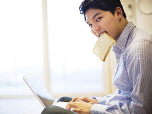 식빵을 입에 물고 노트북을 하는 남자