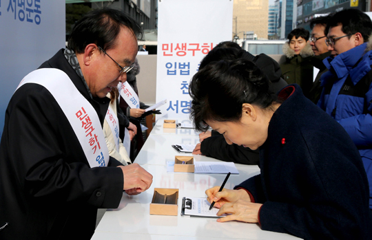 박근혜 대통령이 18일 경기도 성남시 판교테크노밸리 판교역 광장에서 민생구하기 입법촉구 천만서명운동본부가 추진하는 경제활성화법 처리를 촉구하는 서명을 하고 있다.<저작권자(c) 연합뉴스, 무단 전재-재배포 금지 />