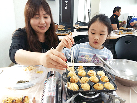 엄마와 딸이 수산항에서 잡은 문어를 이용해 문어빵을 만들고 있다.