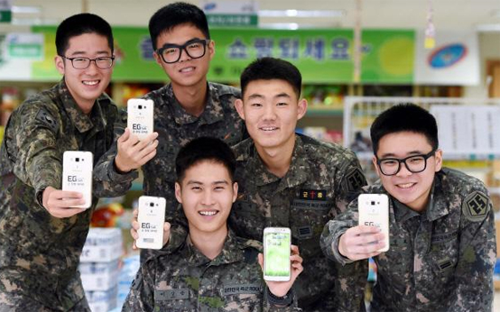 장병 휴대폰 복지서비스를 이용하고 있는 육군25사단 계룡부대 장병들이 스마트폰을 들어 보이며 활짝 웃고 있다.