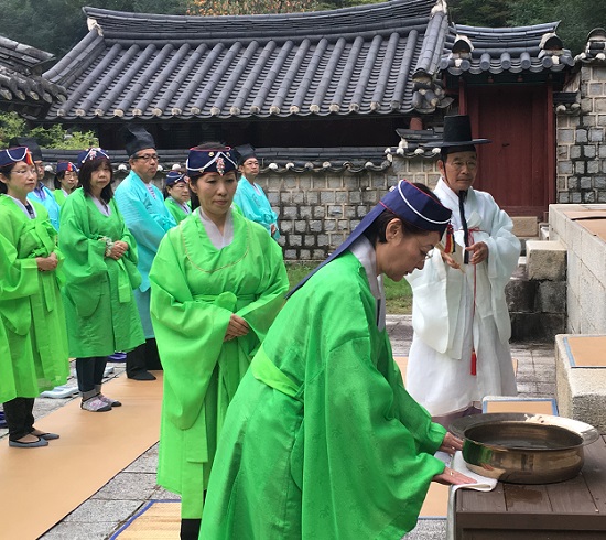제를 올릴 준비를 하고 있는 구로다 후쿠미 씨와 가지런히 공수 하고 있는 관광객들. 