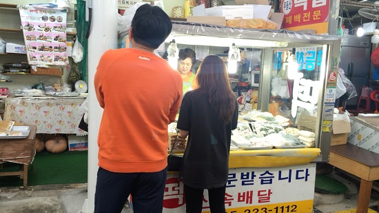  대인시장에서 떡을 구매하는 방문객.