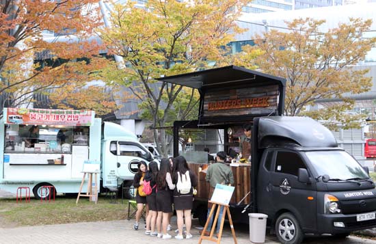 27일 부산 해운대구 벡스코에서 열린 푸드트럭 페스티벌에서 시민들이 거리 음식을 즐기고 있다. 이날 개막한 제4회 대한민국 지방자치박람회 중 국민 화합마당으로 마련된 이 행사에는 전국 9개 도시 20곳에서 운영 중인 푸드트럭 관계자들이 참가했다.<저작권자(c) 연합뉴스, 무단 전재-재배포 금지>