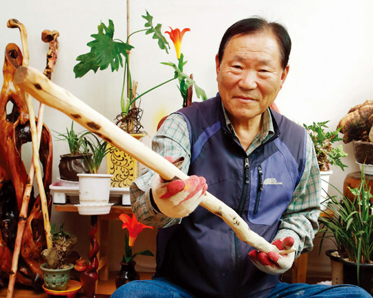 지난해 3월 자택 1층에 마련한 ‘노인건강봉사의 집’ 현판과 노인들의 혈액순환을 돕는 지압봉.