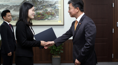 홍용표 통일부 장관이 8일 정규직 공무원이 된 북한이탈주민에게 임명장 수여 후 악수하고 있다.