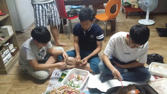 전을 부치고 있는 작은아버지네. 기자의 집은 남자들이 전을 부친다.