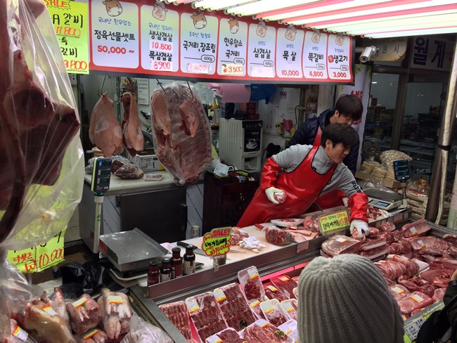 시장 정육점에서 손님의 주문에 따라 부위를 고르고 있다.