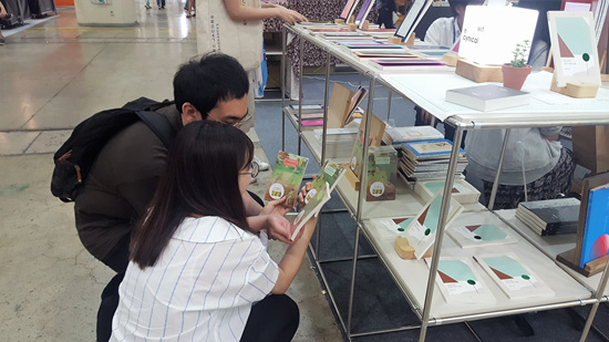 도서전에서 손님이 시집을 고르고 있다.
