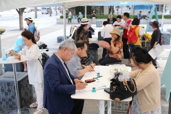 서울 세종로 한글공원에 마련된 광화문 1번가 열린광장에서 국민들이 정책제안서를 쓰고 있다. 