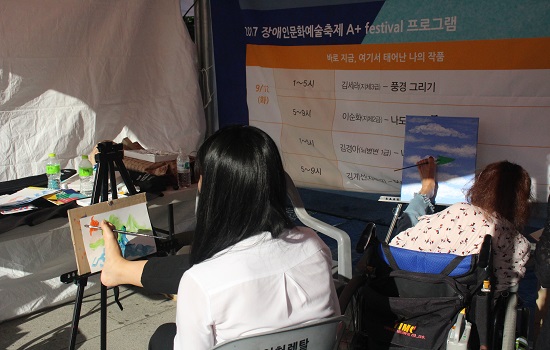 지체장애 3급 김세라 화가와 지체장애인의 어려움을 체험하고 있는 한지호 학생