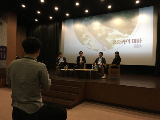 라운드테이블에 참가한 한 청중이 전문가들과 토론하고 있다.