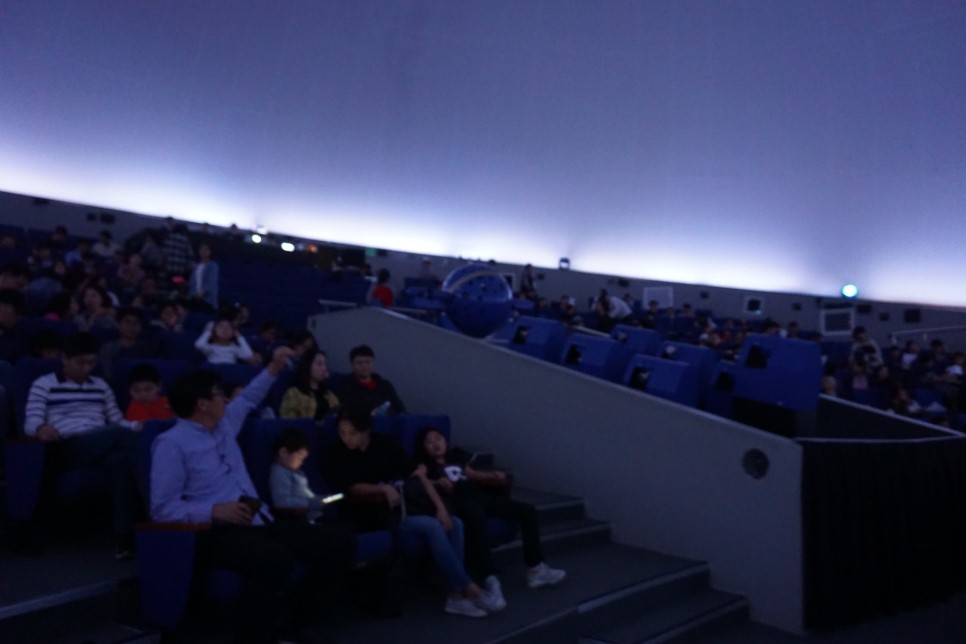 천체투영관 의자안자 기대에 찬 관람객들. 
