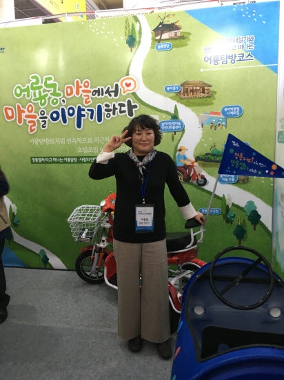 광주 광상구 어룡동 주민자치 부스에서 마을해설사가 깡통열차에서 포즈를 취하고 있다.