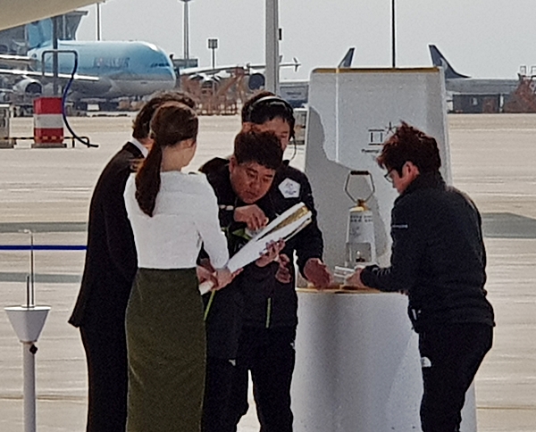 안전램프로 부터 성화로 불을 옮기는 모습.