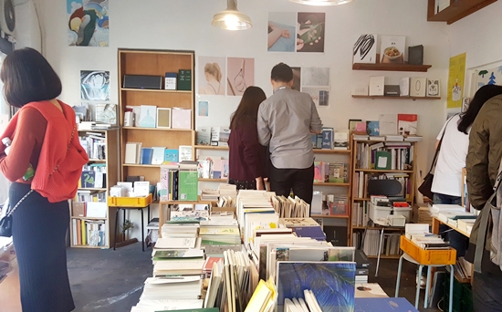 주말 낮, 좁은 책방을 복작하게 메우며 사람들이 책을 살펴보고 있다.