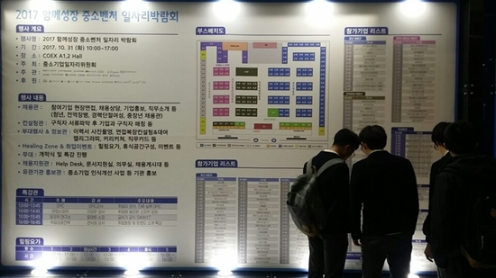 박람회 부스배치도 앞에서 고등학생들이 면접 볼 업체를 찾고있다.