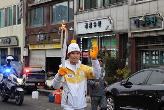 해상공원 방향으로 뛰고 있는 성화봉송 주자.