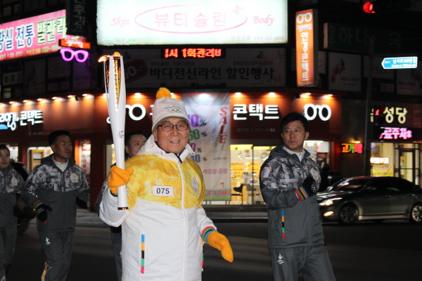 열심히 성화봉송주자로 뛰고 있는 어르신.