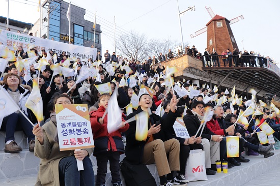 단양 수변공원에서 패러글라이딩 이색 봉송 성화에 환호하고 있는 단양군민들