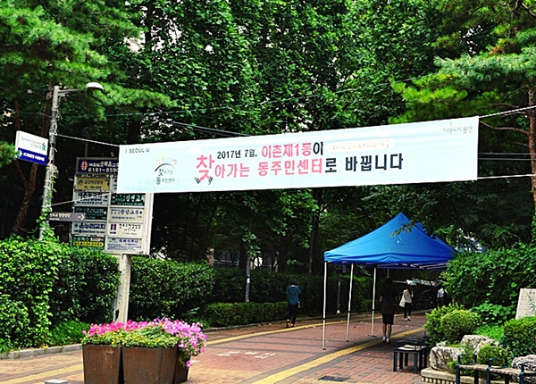 지난 여름 찾아가는 동주민센터 3단계를 알리는 현수막이 전철 역 앞에 나부끼고 있다.