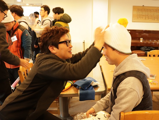 성화봉 체험을 하기 전, 목도리와 장갑, 모자 등 기념품을 선물 받고 있는 체험자들. 