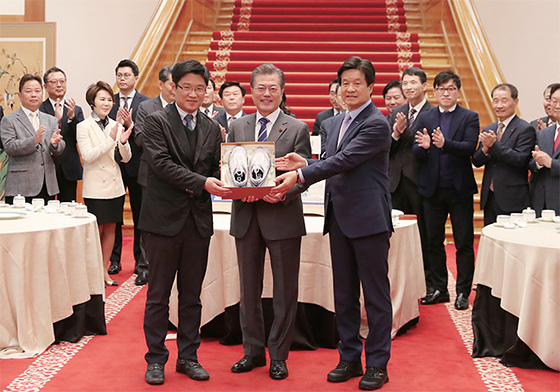 문재인 대통령이 1월 16일 청와대에서 열린 중소, 벤처기업 및 소상공인과의 대화에서 창업 실패 후 재창업을 준비중인 강정완 ㈜공사박사 대표(왼쪽)에게 성공을 기원하며 ‘운동화’를 선물하고 있다.(사진=청와대)