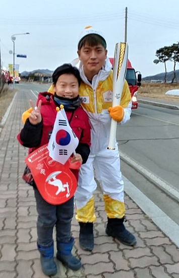 60번 성화봉송 주자가 초등 3학년 황 군과 기념촬영 중이다.