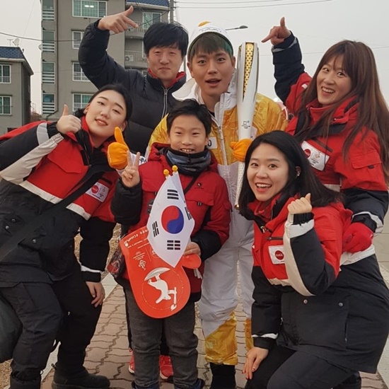 60번 성화봉송 주자가 황 군 및 코카콜라 스텝들과 신나게 응원의 포즈를 취하고 있다.