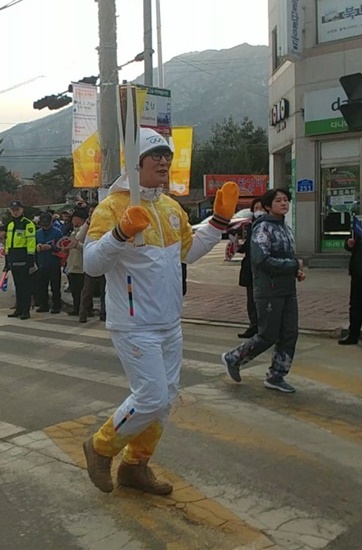 철원의 이평사거리를 지나가는 성화봉송 주자 모습.