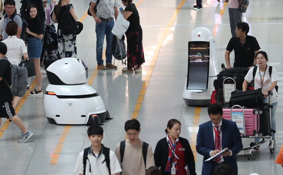 인천공항 출국장의 안내로봇과 청소로봇. (사진=저작권자(c) 연합뉴스, 무단 전재-재배포 금지)