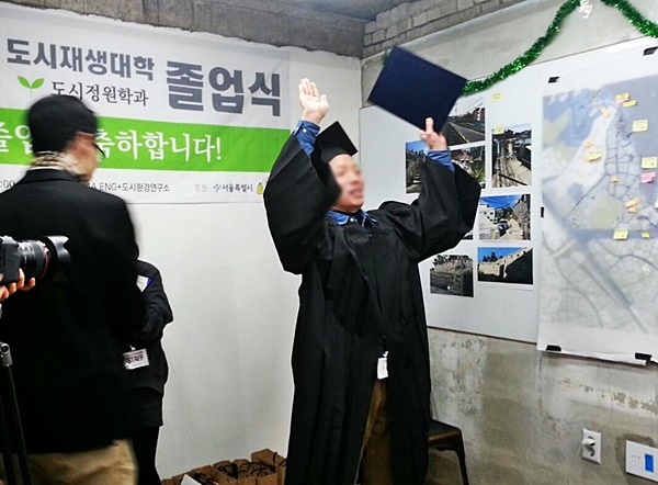 행촌공감도시재생대학 졸업식에서 졸업장을 든 주민이 기뻐하고 있다.