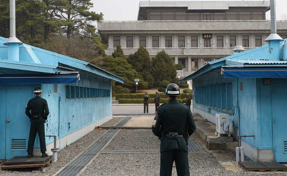 판문점에서 우리 군과 북측 경비병들이 군사분계선을 가운데로 서로를 바라보고 있다.