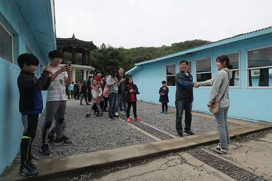 5월 7일 경기 남양주시 남양주종합촬영소 영화 ‘공동경비구역 JSA’의 판문점 세트장에서 관람객이 남북정상회담 장면을 재현하고 있다.(사진=저작권자(c) 연합뉴스, 무단 전재-재배포 금지)