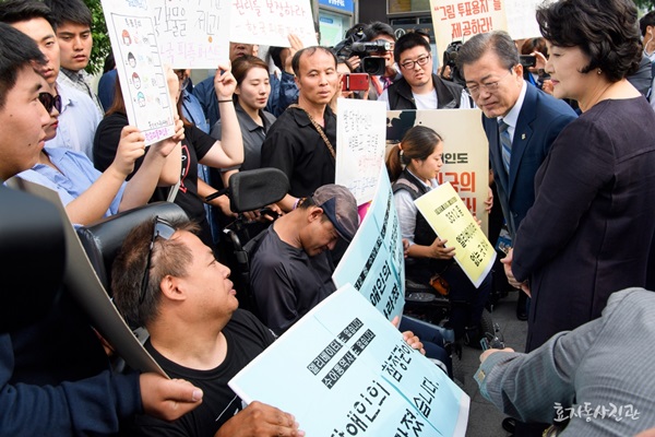 문재인 대통령이 8일 오전 서울 종로구 삼청동주민센터에 마련된 사전투표소에서 6.13 지방선거 사전투표를 마친 후 장애인 참정권을 요구하는 장애인단체 회원들과 만나고 있다.(출처=효자동사진관)