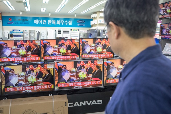 김정은 북한 국무위원장과 도널드 트럼프 미국 대통령의 첫 북미정상회담이 열린 12일 오전 서울 용산 전자랜드 TV매장에서 북미정상회담 한 시민이 생중계 화면이 방송되고 있다.(출처=뉴스1) 
