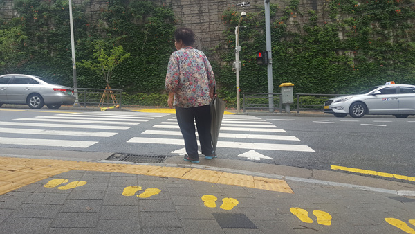 차도 가까이 서서 신호를 기다리는 시민