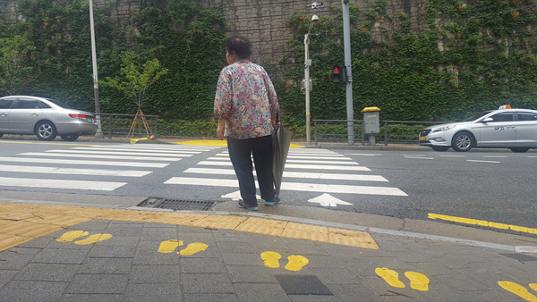 차도 가까이 서서 신호를 기다리는 시민