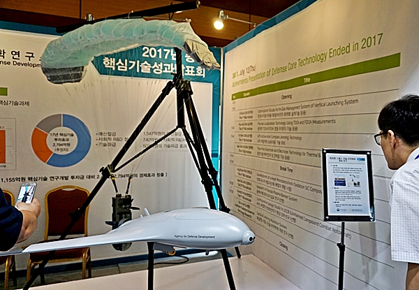 사진을 찍고 문의를 하며 큰 관심을 갖는 관람객들.
