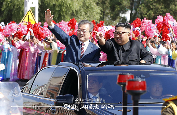 문재인 대통령과 김정은 국무위원장이 무개차를 함께 타고 순안공항에서 백화원 영빈관으로 이동하고 있다. ⓒ 평양사진공동취재단