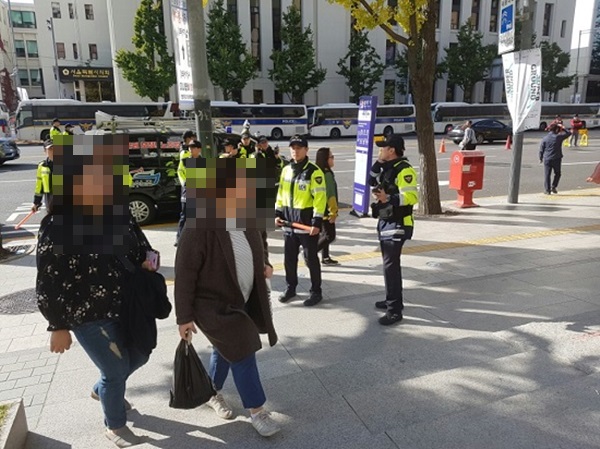 경찰관의 안내에 따라 시위 바깥으로 이동하고 있는 시민들.